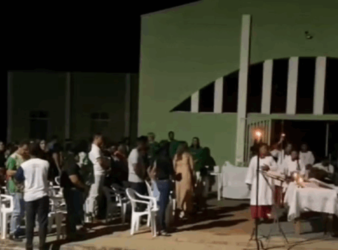 A igreja precisou se adaptar e os fiéis participaram da missa apenas com a iluminação do poste de energia e ao ar livre — Foto: Reprodução