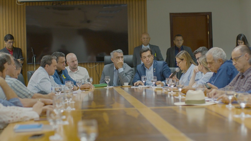 Contando com a participação do setor agropecuário, de deputados e de gestores públicos estaduais, ocorreu nesta terça-feira (23), na Assembleia Legislativa do Estado do Tocantins (Aleto), reunião convocada pela Frente Parlamentar do Agronegócio (FPA), presidida pelo deputado estadual Gutierrez Torquato, para tratar da participação do setor produtivo e da transparência contratual do Programa de JREDD+ (Redução de Emissão de Gases do Efeito Estufa por Desmatamento e Degradação) entre a Tocantins Parcerias (TOPAR) e a empresa Mercuria Energy Trading, que resultou na criação da Sociedade de Propósito Específico (SPE), Tocantins Carbono (TOCAR). O encontro contou com a presença de membros da Tocantins Carbono (TOCAR) e da Mercuria Energy Trading S.A., empresa parceira do Estado na certificação e monetização dos ativos, posicionando o Tocantins como o primeiro estado do Brasil e um dos pioneiros no mundo nesta iniciativa.

Na ocasião, foi pactuada a instalação de uma comissão técnica com representação do setor agropecuário, do Governo do Tocantins e da Mercuria, com o objetivo de analisar e discutir o acordo, que possibilita os pré-investimentos para implementação do Programa. “Foi muito importante a participação efetiva dos entes representativos do agronegócio. Avançaremos já na próxima semana com os levantamentos feitos para discutir com a Mercuria e com o Governo, que participa por meio do Naturatins, da Secretaria da Agricultura, da Tocantins Parcerias (TOPAR) e da Secretaria do Meio Ambiente. Será um projeto construído a várias mãos”, afirmou o deputado Gutierrez Torquato, presidente da FPA na Aleto.
Durante a reunião, o Executivo da Mercuria esclareceu que a transparência e a ampla discussão são premissas básicas para o sucesso do programa. Neste sentido, através da comissão técnica representativa, serão disponibilizadas todas as informações necessárias para subsidiar o trabalho de todos os envolvidos nessa importante discussão.

Esclarecimentos

O Programa JREDD+ é um instrumento econômico que visa promover o desenvolvimento de baixas emissões e, portanto, reduzir as emissões de gases de efeito estufa por desmatamento e degradação florestal, que no caso do Tocantins são as queimadas. Neste caso, a  Mercuria foi a empresa vencedora do edital de chamamento público da TOPAR para contribuir com o estado do Tocantins no processo de certificação e registro dos créditos de carbono do Programa JREDD+, etapa que habilita o Tocantins a comercializar créditos no mercado voluntário de carbono, posicionando o Estado como o primeiro estado subnacional do mundo a submeter o documento de registro ao padrão Internacional ART TREES.


A Mercuria também informou que a comercialização dos créditos de carbono do Tocantins somente poderá ocorrer após a emissão e o depósito desses créditos no sistema da certificadora. A empresa comunicou, ainda, que o investimento inicial necessário ao processo de certificação  vem sendo realizado integralmente a risco da Empresa, por meio de uma sociedade de propósito específico (SPE) constituída com a Tocantins Parcerias.


Ações

Na reunião, o executivo da Mercuria reforçou as diretrizes já adotadas pelo JREDD+ no Tocantins, como participação social, governança multissetorial e salvaguardas socioambientais. Essas diretrizes vêm sendo implementadas em diversas oficinas regionais de Consulta Livre, Prévia e Informada (CLPI), que mapearam prioridades territoriais, demandas de regularização fundiária, bioeconomia, turismo de base comunitária e mecanismos de repartição de benefícios, com foco na redução de emissões de gases de efeito estufa, na proteção da sociobiodiversidade e na geração de renda local 