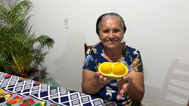 Presidente Aldenora Martins dos Santos apresentando o fruto do pequi 
