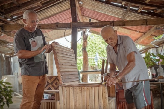 Antônio Luiz Ribeiro da Neves, conhecido como Tauru, ao lado do pai, José Fernandes Neves, o Seu Zeca, mestre artesão de Porto Nacional. A produção de móveis em madeira de buriti segue como ofício familiar, mantendo a prática ativa entre gerações - Créditos: Kadu Souza/Governo do Tocantins
