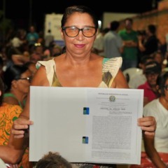 A benefici&aacute;ria Maria Creusa Concei&ccedil;&atilde;o Almeida recebe o t&iacute;tulo definitivo de seu im&oacute;vel no Setor Barros, em Aragua&iacute;na, ap&oacute;s 33 anos de espera. - Lucas Nascimento/TJTO 