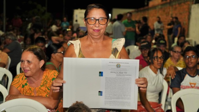A beneficiária Maria Creusa Conceição Almeida recebe o título definitivo de seu imóvel no Setor Barros, em Araguaína, após 33 anos de espera. - Lucas Nascimento/TJTO 