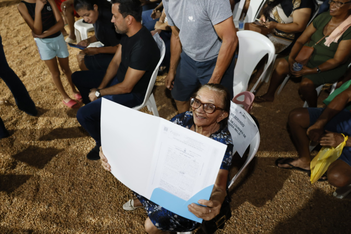 Moradora do Setor Lago Norte, Maria de Lourdes de Sousa Melo, de 82 anos, foi a primeira a receber o título de propriedade recebe seu título — Crédito da foto: Edu Fortes Moradora do Setor Lago Norte, Maria de Lourdes de Sousa Melo, de 82 anos, foi a primeira a receber o título de propriedade recebe seu título — Crédito da foto: Edu Fortes