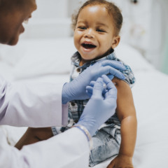 Toddler getting a vaccination by a pediatrician